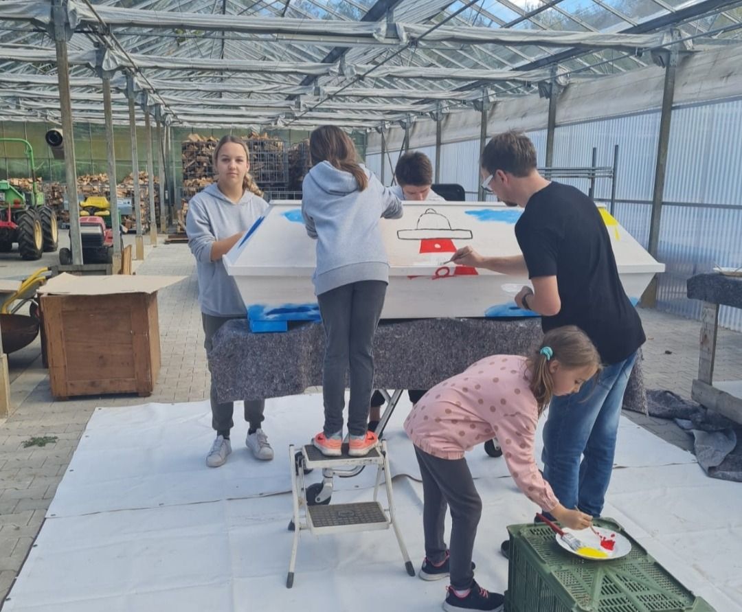 Hier bemalen die Kinder gemeinsam einen Sarg