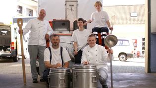 Die Köche aus der Feldküche beim Gruppenfoto mit Kochgeschirr