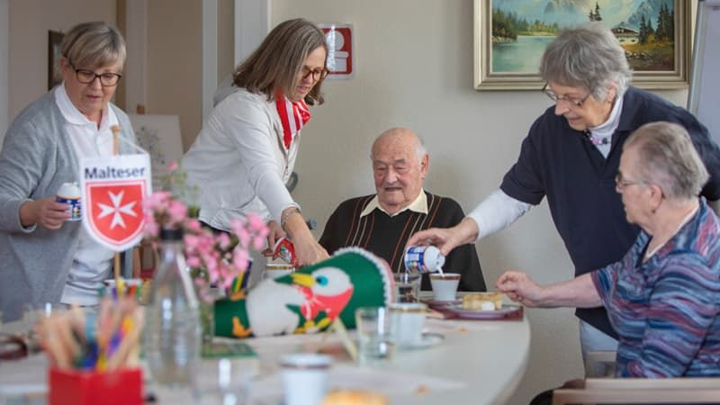 Mitarbeitende des Malteser Cafe Malta bereiten eine Kaffee-Tafel für das Demenztreffen vor.