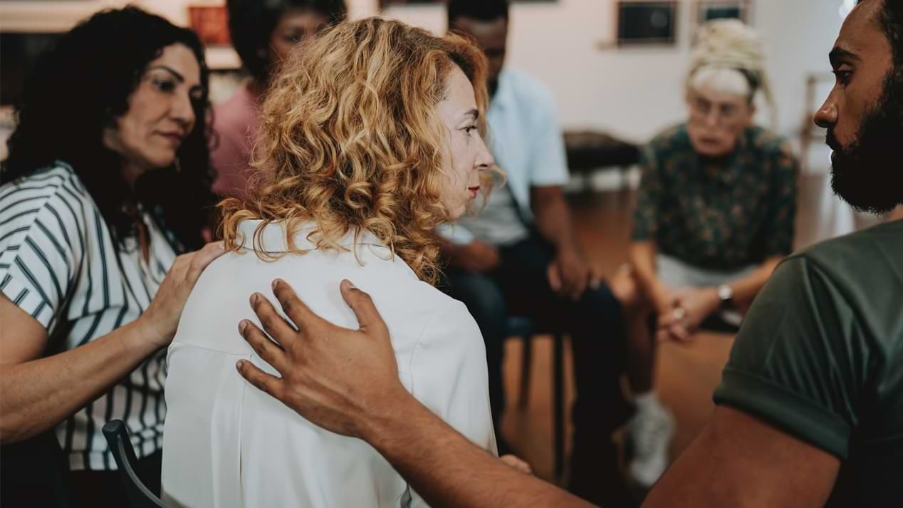 Menschen sitzen im Kreis in einer Trauergruppe