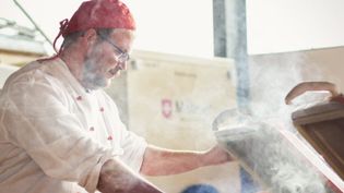 Koch kocht in einer Feldküche. 