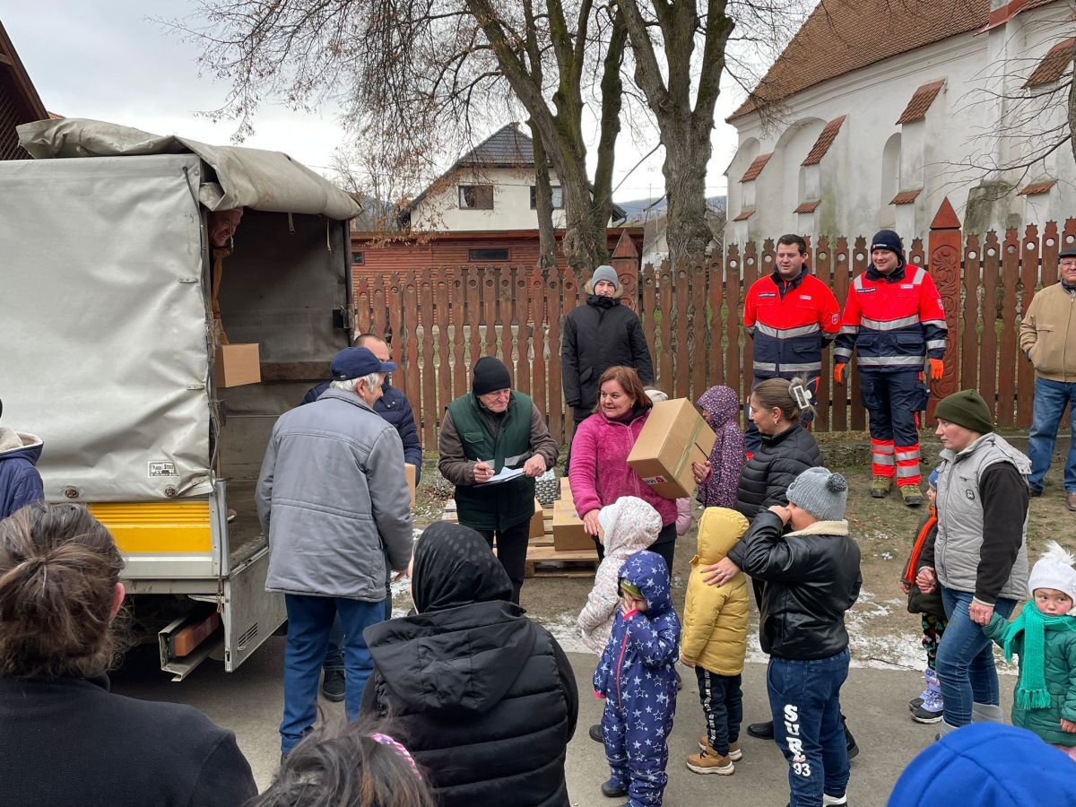 Menschen mit Paketen vor einem großen Haus