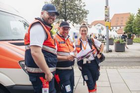 Malteser vor dem Auto, die Hilfe anbieten