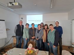 Gruppenfoto der acht neuen Ehrenamtlichen im Schulungsraum