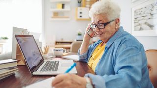 Rentnerin übt ein Ehrenamt am Laptop aus.