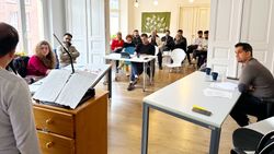 Menschen debattieren über ein Thema und werden von Zuschauern beobachtet