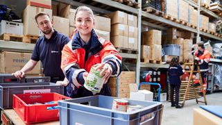Malteser Helfende sortieren Waren in einem Lager
