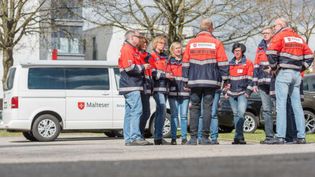 Mehrere Helferinnen und Helfer des PSNV-Teams beraten sich. Im Hintergrund ist ein Fahrzeug (Bulli) des PSNV-Teams zu sehen.