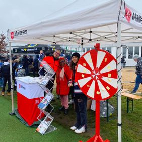 Malteser mit Glücksrad stehen beim 12. Behindertentag des 1. FC Magdeburg