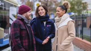 Ehrenamtlerin des Malteser Integrationsdienstes unterhält sich mit einer Frau und einem Mann.