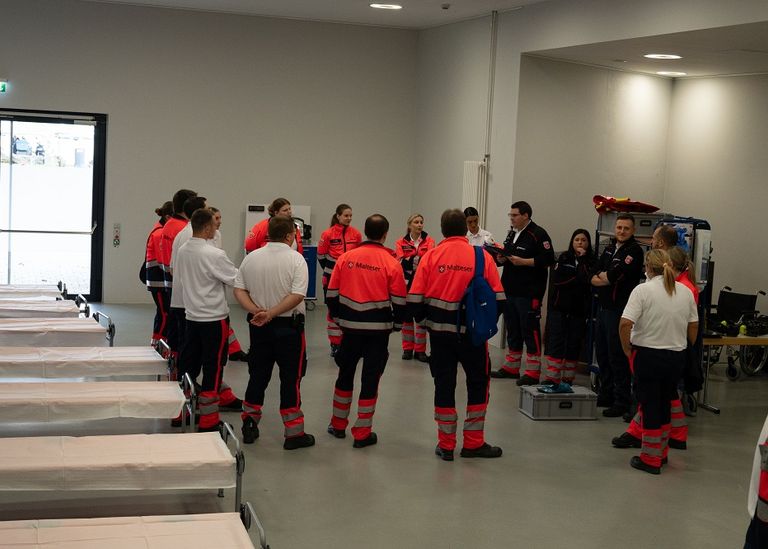 Malteser in Einsatzkleidung bei einer Halle