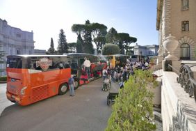 Zu sehen sind 3 Reisebusse bei ihrer Ankunft in Rom sowie die Pilgerinnen und Pilger 