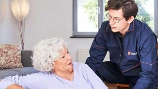  Hausnotruf Mitarbeiter der Malteser hilft einer gestürzten Dame zuhause. 