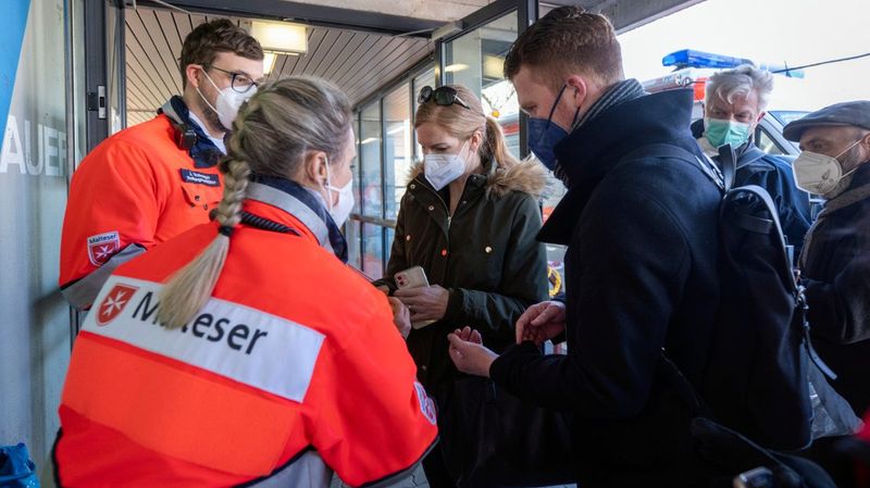 Zwei Angehörige der Malteser in Deutschland mit Geflüchteten aus der Ukraine.