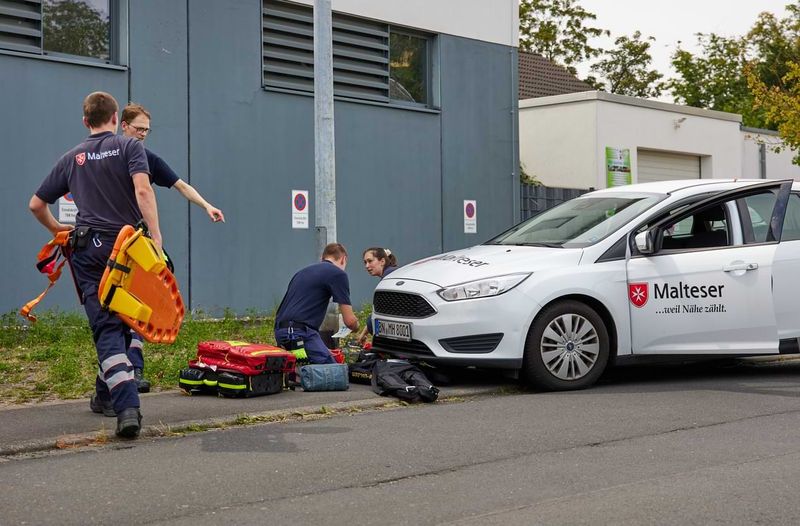 Eine junge Frau in Uniform stellt ein Warnschild mit der Aufschrift „Patientenablage“ auf.