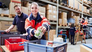 Malteser Helfende sortieren Waren in einem Lager