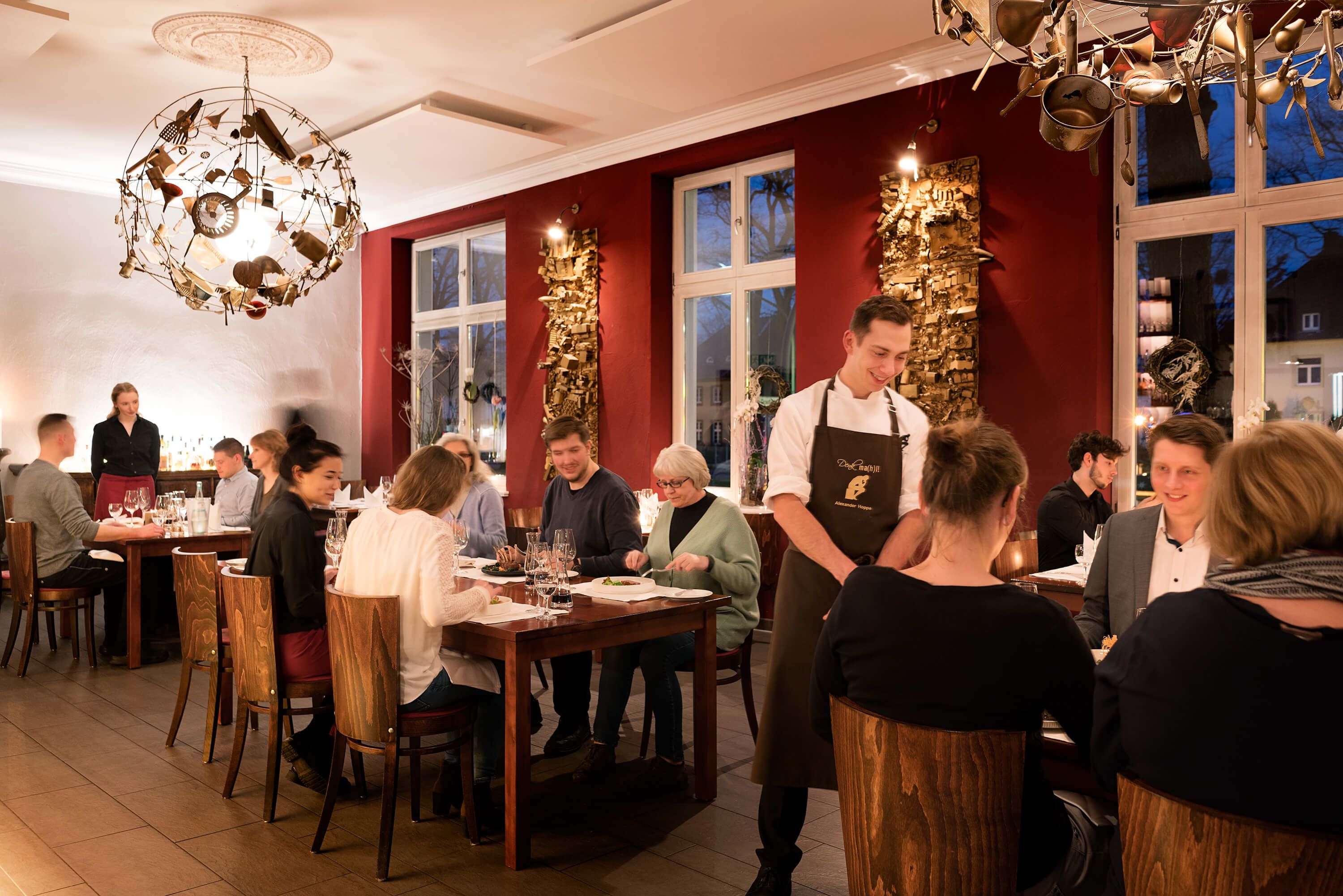 Koch unterhält sich mit Gästen im Restaurant