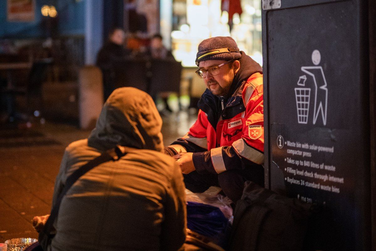 Zwei Männer knien auf einem Bürgersteig