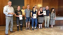 Eine Gruppe von Menschen erhält eine Auszeichnung. Sie haben beim Stadtradeln mitgemacht.