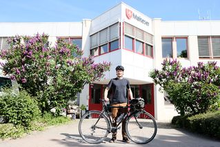 Mann mit Fahrrad vorm Malteser Gebäude