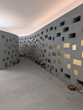 Blick in einen Gang des Kolumbariums mit durch Messingschilder verschlossenen Urnenplätzen links und rechts