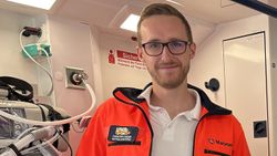 Ein Mann in rettungsdienstlicher Bekleidung im Inneren eines RTW blickt freundlich in die Kamea.