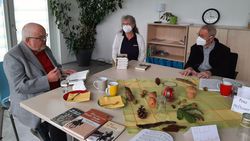 Autor Günter Neidinger sitzt mit einer Frau und einem Mann am Tisch beim Café Malta.