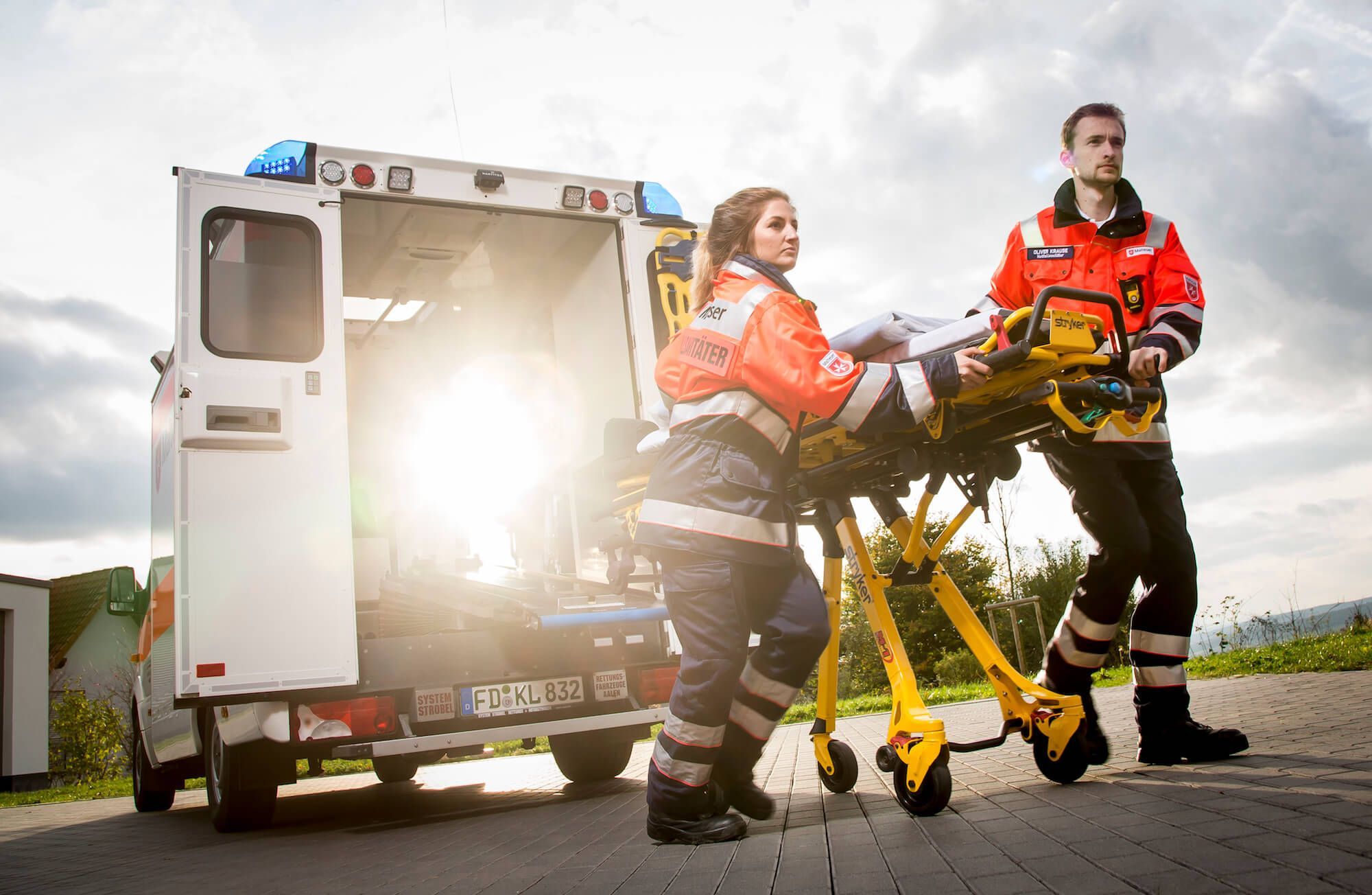 Zwei Rettungssanitäter schieben die Trage aus dem Retungswagen