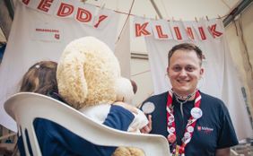 Ein Jugendlicher zusammen mit einem Kind und Teddy