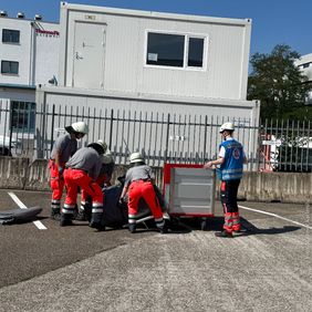 Helferinnen und Helfer laden das Zelt aus