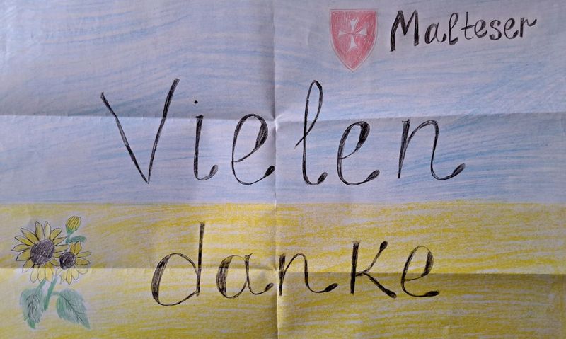 Ein Blatt Papier in den Farben der ukrainischen Flagge mit der Aufschrift „Vielen danke“