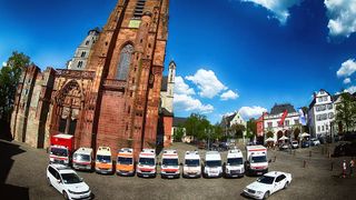 Malteser Fahrzeuge stehen auf dem Kirchplatz.