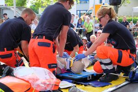 Im Anschluss an die fingierte Telefonreanimation „übernehmen“ die Rettungskräfte bis zum Transport ins Krankenhaus. Gespannt schauen vor allem auch die kleinen Gäste zu.