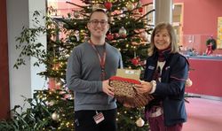 Eine Frau in Malteser Kleidung überreicht einem Mann eine Kiste mit Briefen