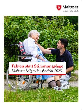 Eine Frau sitzt im Rollstuhl. Ein Mann kniet vor ihr. 