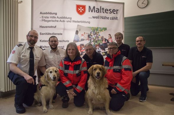 Gruppenbild: Frauen und Männer mit den Malteser Rettungshunden