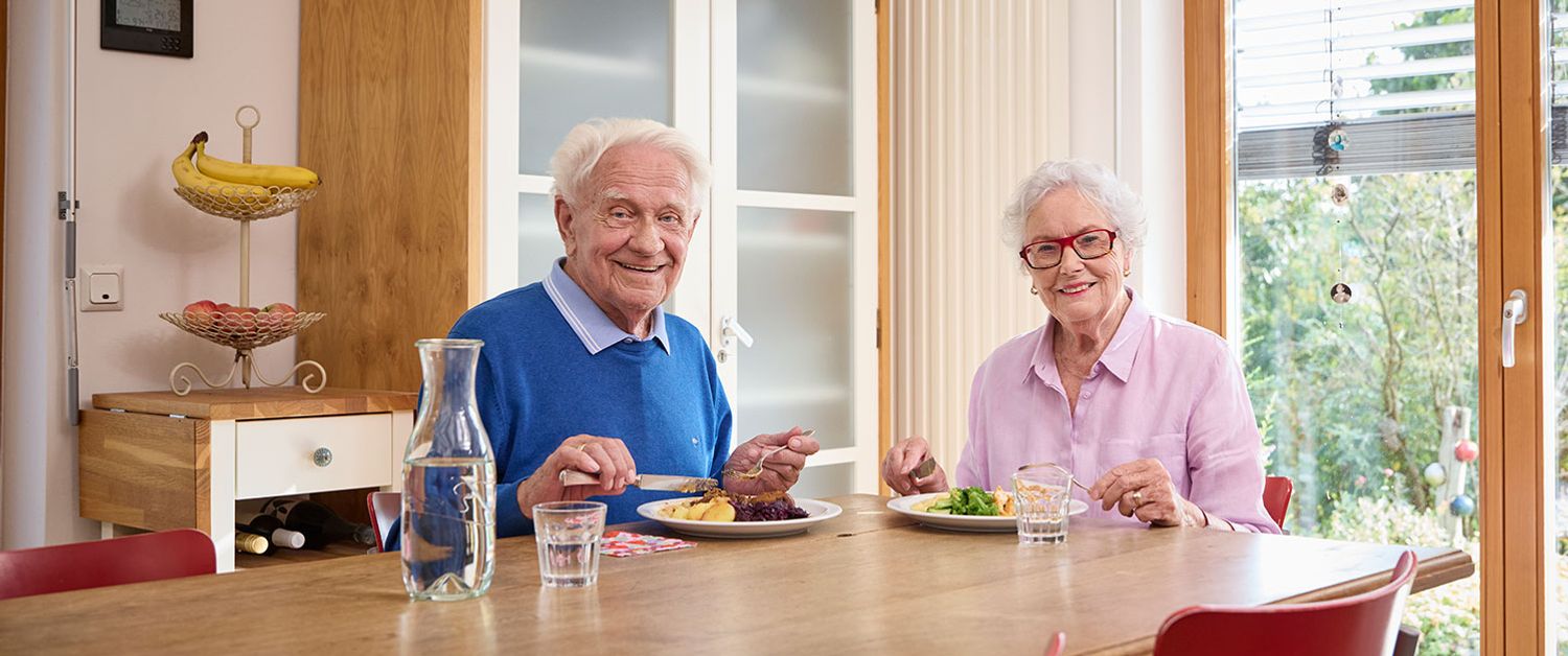 Eine Frau und ein Mann essen ein Gericht vom Malteser Menüservice
