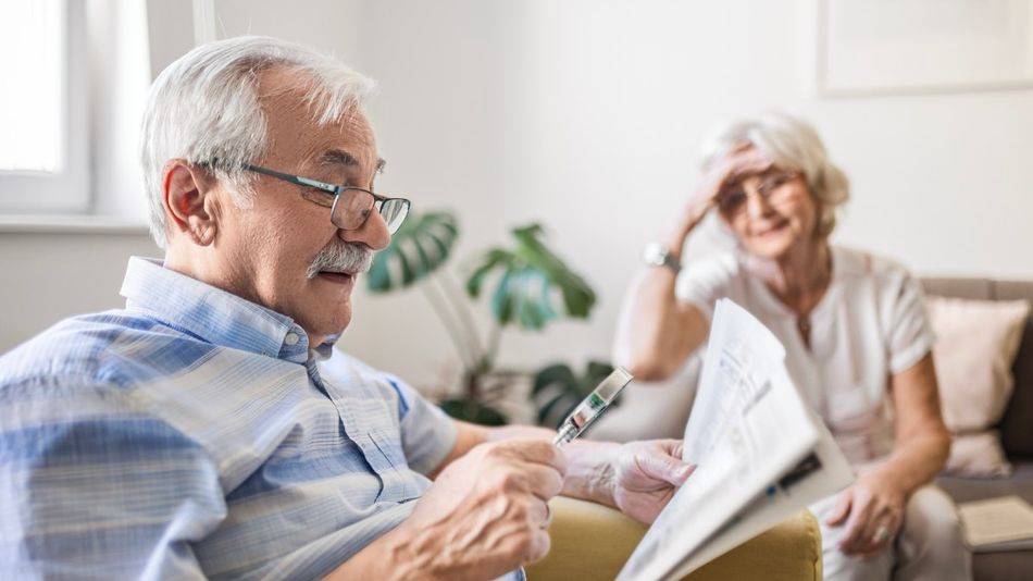 Zeitung lesen mit Lupe