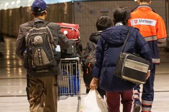 Ein Malteser begleitet drei aus der Ukraine geflüchtete Menschen in der zentralen Unterkunft des Landes in Stuttgart. Foto: Malteser