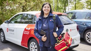 Malteser Hausnotruf Bereitschaftsdienstmitarbeiterin lächelt in die Kamera.