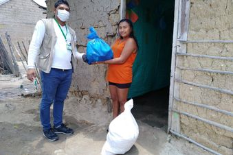 HIlfe in Not: Eine Frau bekommt von einem Helfer Lebensmittel und Hygieneartikel übergeben. Foto: Abiudea/Malteser