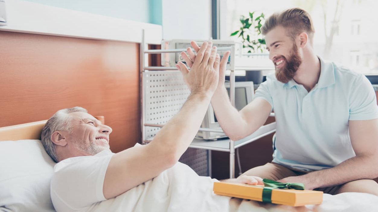 Junger Mann gibt Pflegebedürftigem ein High Five