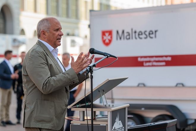 Ein Mann steht am Mikrofon und hält eine Rede