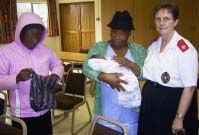 Two women and a care worker with an infant at the Children’s Home.