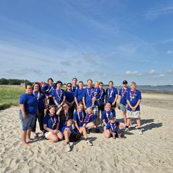 Gruppenfoto Bundesjugendlager Teilnehmende Bistum Limburg. Die 25 Teilnehmenden stehen im gleichen Bundesjugendlager-T-Shirt am Strand.