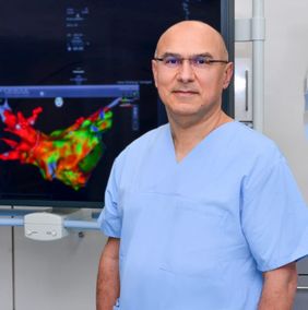Stehender Mann in Funktionskleidung vor einem farbigen Monitor.