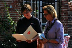 Zwei Frauen betrachten gemeinsam ein Dokument.