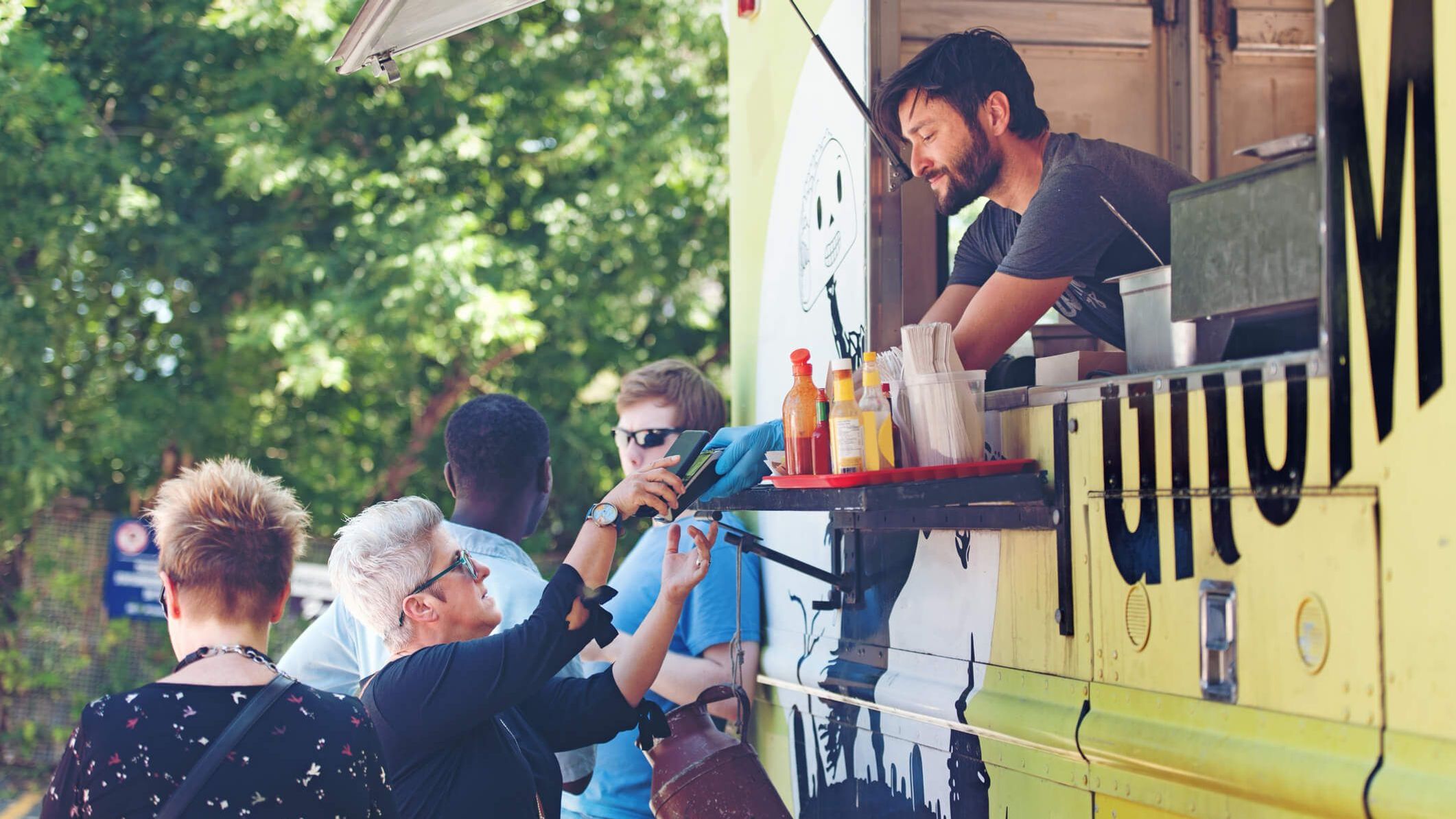 Mann bedient ältere Dame aus einem Foodtruck