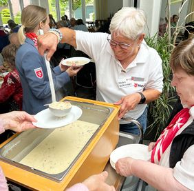 Personen stehend, Suppe, Teller