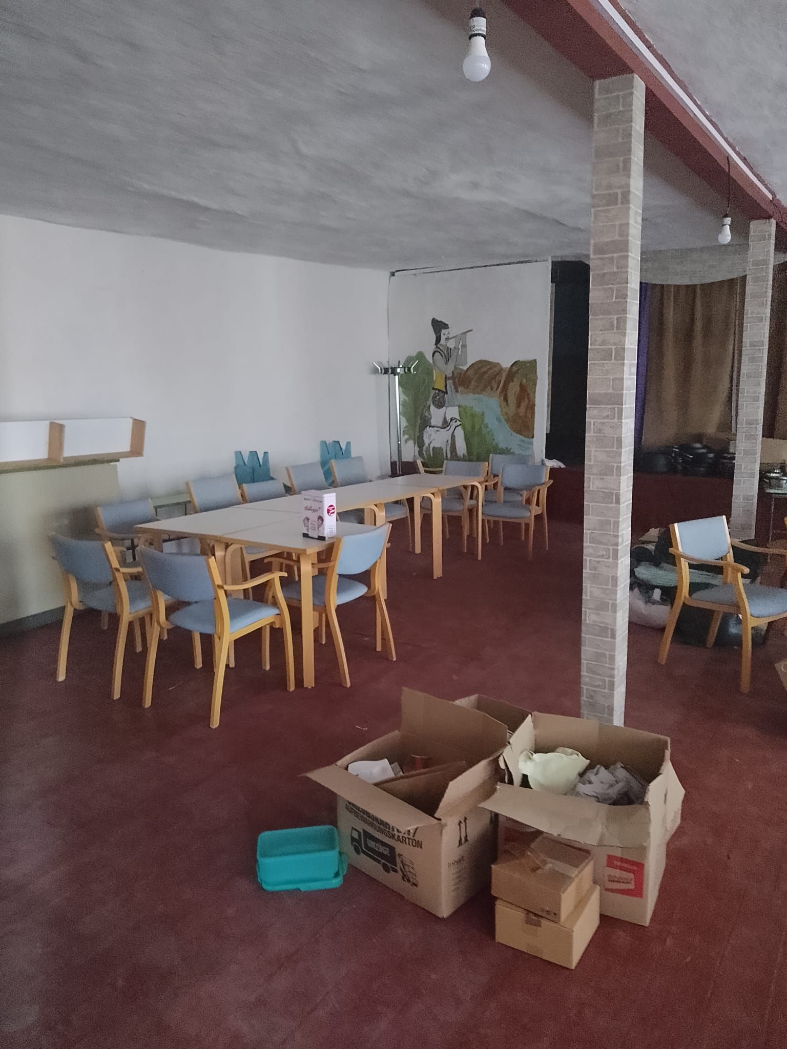 innenansicht der kleiderkammer vor der sanierung, eine tischgruppe steht an einer wand